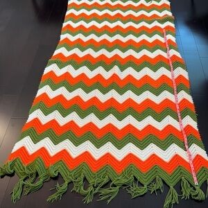 Chevron knitted throw 86 inches long and 40 inches wide. Orange white and olive.